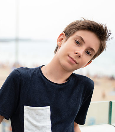 Handsome young boy looking at camera over panorama of Alicante.