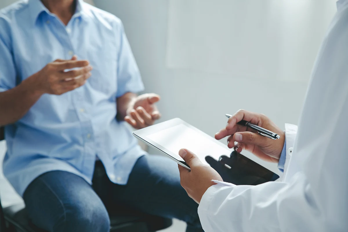 Best age for gynecomastia: Male patient consulting with doctor while discussing treatment options