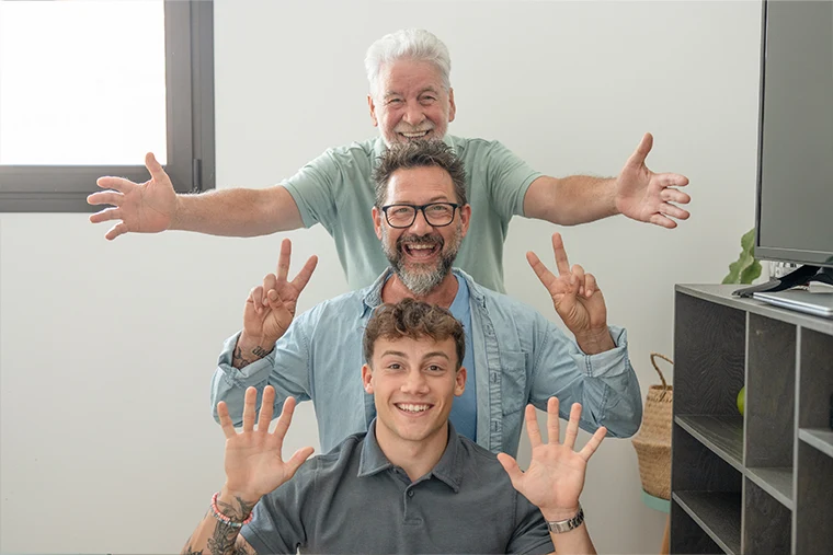 Best age for gynecomastia: Three generations of men smiling together, showing different life stages